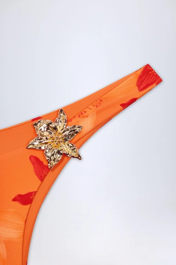 Beqa Bikinibyxor med metalldetaljer i orange orkidé-mönster Beqa Bikinibyxor med metalldetaljer i orange orkidé-mönster