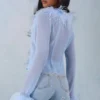 Elisia genomskinlig topp med fjäderkant i mjukblått Elisia genomskinlig topp med fjäderkant i mjukblått