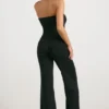 Grovstickad bandeau-jumpsuit med utsvängda ben i svart Grovstickad bandeau-jumpsuit med utsvängda ben i svart