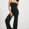 Grovstickad bandeau-jumpsuit med utsvängda ben i svart Grovstickad bandeau-jumpsuit med utsvängda ben i svart