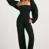 Grovstickad bandeau-jumpsuit med utsvängda ben i svart Grovstickad bandeau-jumpsuit med utsvängda ben i svart