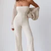 Jumpsuit i grovstickat tyg med bandeau-halsringning och utsvängda byxben i krämfärg Jumpsuit i grovstickat tyg med bandeau-halsringning och utsvängda byxben i krämfärg