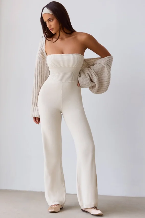 Jumpsuit i grovstickat tyg med bandeau-halsringning och utsvängda byxben i krämfärg Jumpsuit i grovstickat tyg med bandeau-halsringning och utsvängda byxben i krämfärg