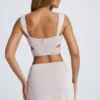 Kira Crop Top med utskärningar och detaljer i metall i himmelsgrått Kira Crop Top med utskärningar och detaljer i metall i himmelsgrått