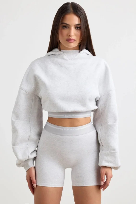 Kort hoodie i stretchig bomullsfleece i gråmelerat Kort hoodie i stretchig bomullsfleece i gråmelerat