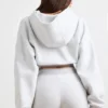 Kort hoodie i stretchig bomullsfleece i gråmelerat Kort hoodie i stretchig bomullsfleece i gråmelerat