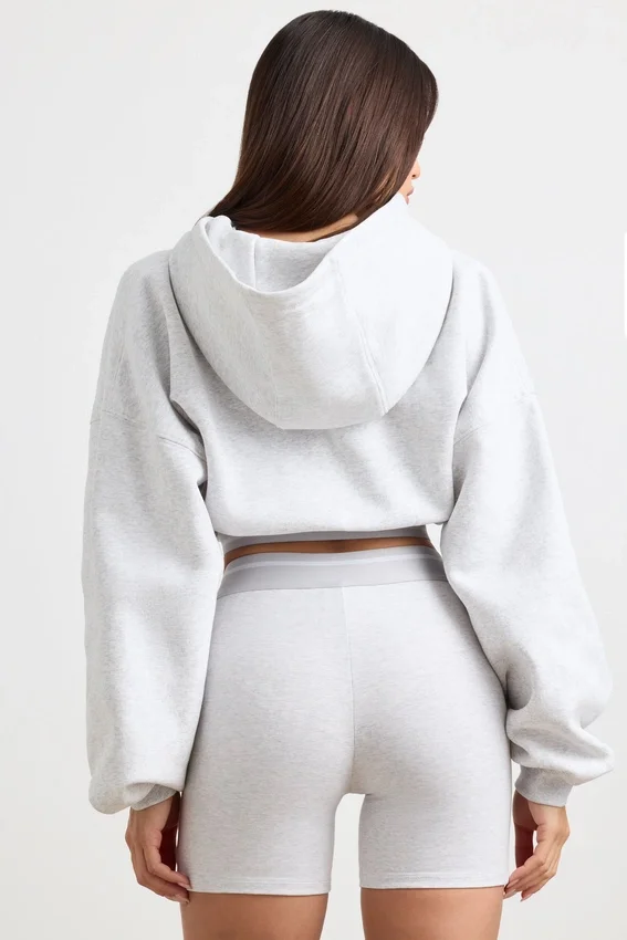 Kort hoodie i stretchig bomullsfleece i gråmelerat Kort hoodie i stretchig bomullsfleece i gråmelerat