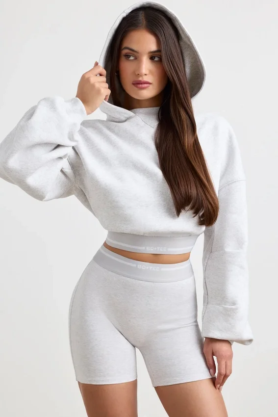 Kort hoodie i stretchig bomullsfleece i gråmelerat Kort hoodie i stretchig bomullsfleece i gråmelerat