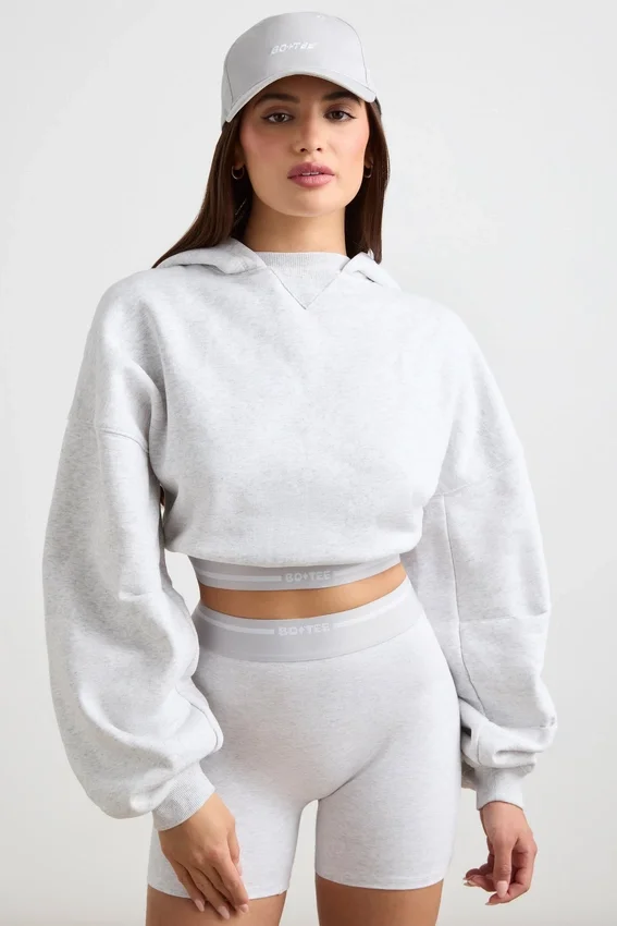 Kort hoodie i stretchig bomullsfleece i gråmelerat Kort hoodie i stretchig bomullsfleece i gråmelerat