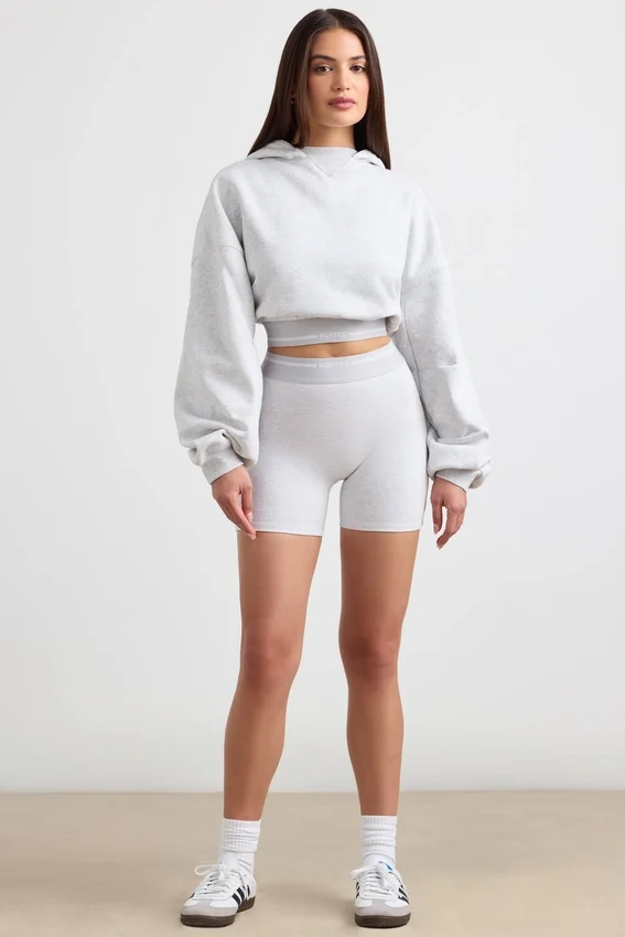 Kort hoodie i stretchig bomullsfleece i gråmelerat Kort hoodie i stretchig bomullsfleece i gråmelerat