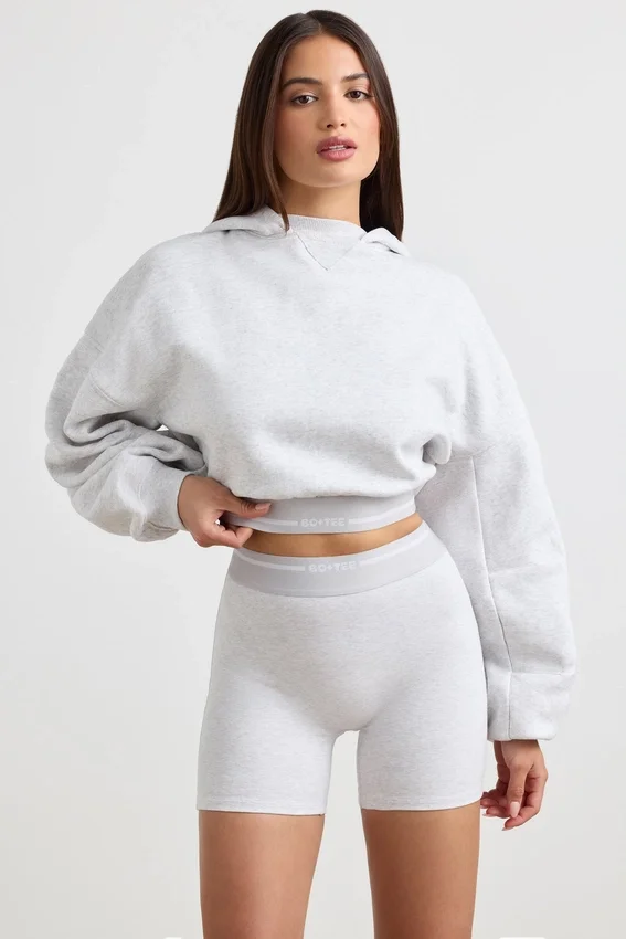 Kort hoodie i stretchig bomullsfleece i gråmelerat Kort hoodie i stretchig bomullsfleece i gråmelerat