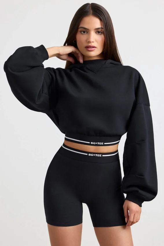 Kort hoodie i stretchig bomullsfleece i svart Kort hoodie i stretchig bomullsfleece i svart
