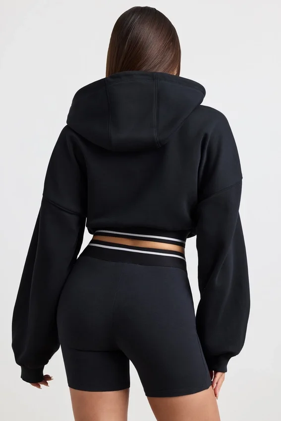 Kort hoodie i stretchig bomullsfleece i svart Kort hoodie i stretchig bomullsfleece i svart