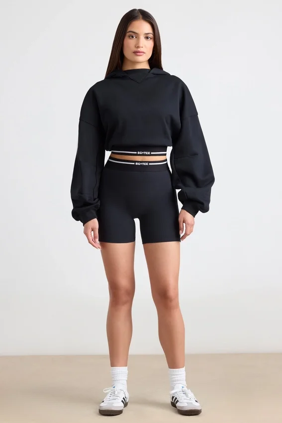 Kort hoodie i stretchig bomullsfleece i svart Kort hoodie i stretchig bomullsfleece i svart