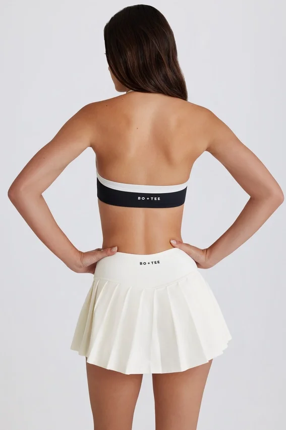 Mjuk, aktiv tennis-skort med plissering och låg midja i färgen Ivory Mjuk, aktiv tennis-skort med plissering och låg midja i färgen Ivory
