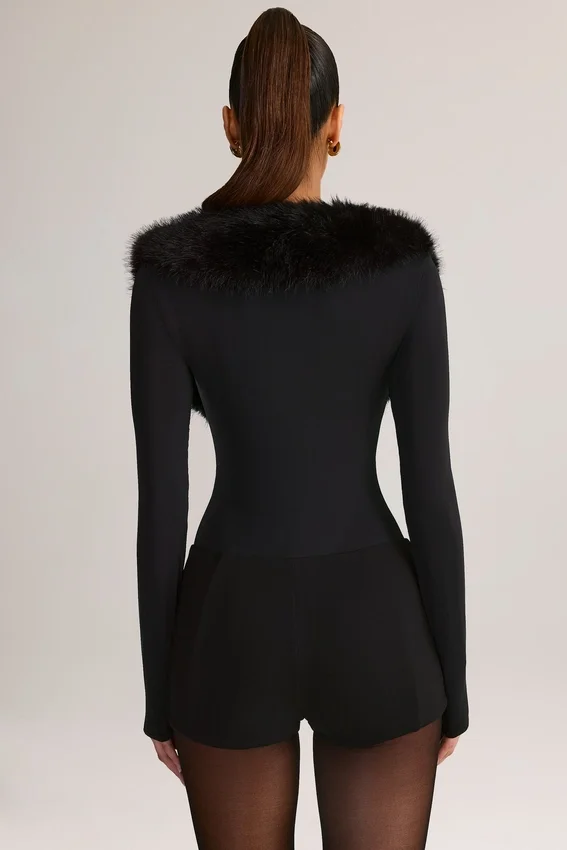 Nesta korsettplaysuit med fuskpälskant i svart Nesta korsettplaysuit med fuskpälskant i svart