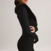 Nesta korsettplaysuit med fuskpälskant i svart Nesta korsettplaysuit med fuskpälskant i svart