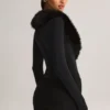 Nesta korsettplaysuit med fuskpälskant i svart Nesta korsettplaysuit med fuskpälskant i svart