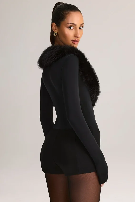 Nesta korsettplaysuit med fuskpälskant i svart Nesta korsettplaysuit med fuskpälskant i svart