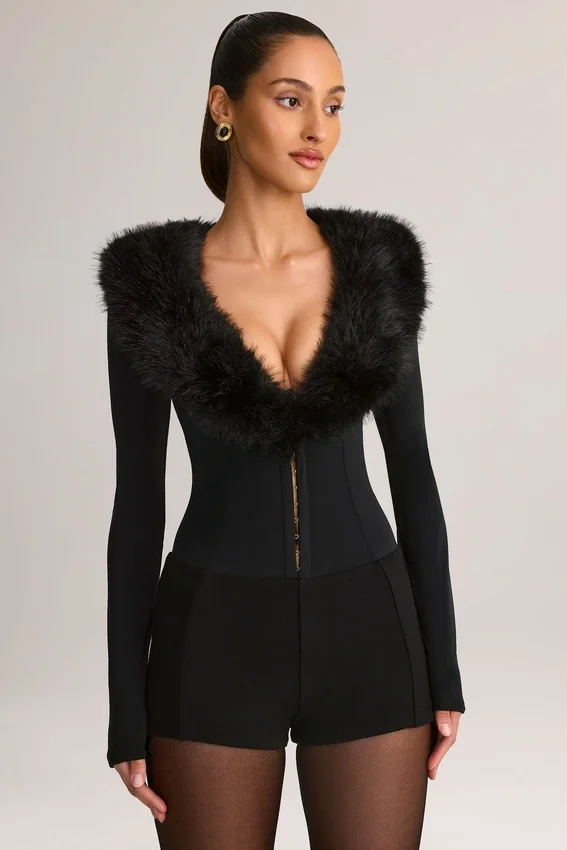 Nesta korsettplaysuit med fuskpälskant i svart Nesta korsettplaysuit med fuskpälskant i svart