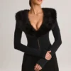Nesta korsettplaysuit med fuskpälskant i svart Nesta korsettplaysuit med fuskpälskant i svart