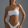 Oh Polly Badkläder: HOTFIX Edition Bandeau-bikinitopp med en axel och dekorationer i vitt Oh Polly Badkläder: HOTFIX Edition Bandeau-bikinitopp med en axel och dekorationer i vitt