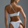 Oh Polly Badkläder: HOTFIX Edition Bandeau-bikinitopp med en axel och dekorationer i vitt Oh Polly Badkläder: HOTFIX Edition Bandeau-bikinitopp med en axel och dekorationer i vitt