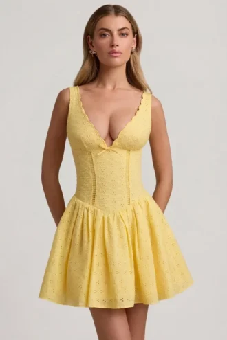 Sabina A-linjeformad miniklänning med broderie anglaise och rosettdetalj i pastellgult Sabina A-linjeformad miniklänning med broderie anglaise och rosettdetalj i pastellgult