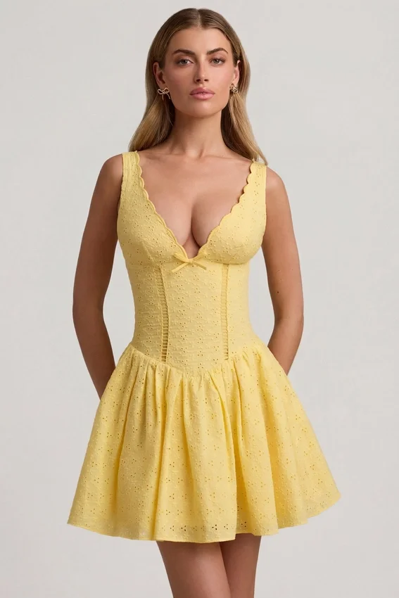 Sabina A-linjeformad miniklänning med broderie anglaise och rosettdetalj i pastellgult Sabina A-linjeformad miniklänning med broderie anglaise och rosettdetalj i pastellgult