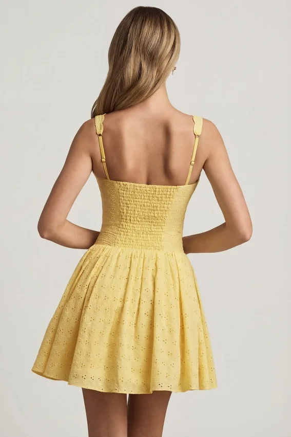 Sabina A-linjeformad miniklänning med broderie anglaise och rosettdetalj i pastellgult Sabina A-linjeformad miniklänning med broderie anglaise och rosettdetalj i pastellgult