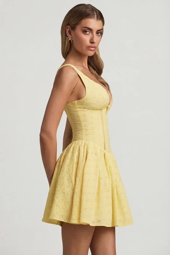 Sabina A-linjeformad miniklänning med broderie anglaise och rosettdetalj i pastellgult Sabina A-linjeformad miniklänning med broderie anglaise och rosettdetalj i pastellgult