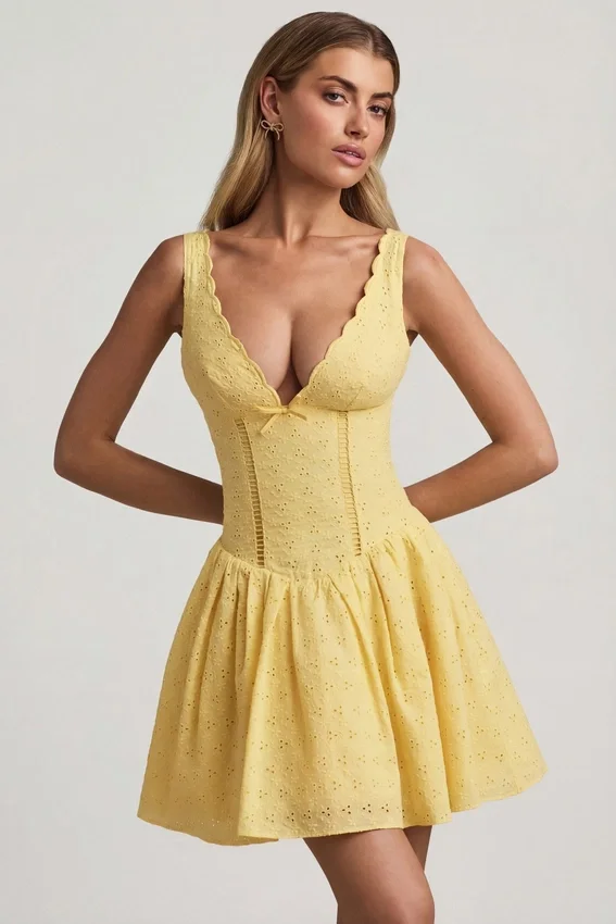Sabina A-linjeformad miniklänning med broderie anglaise och rosettdetalj i pastellgult Sabina A-linjeformad miniklänning med broderie anglaise och rosettdetalj i pastellgult