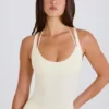 Stretchig bomullsjersey-bodys med korsrygg i krämfärg Stretchig bomullsjersey-bodys med korsrygg i krämfärg