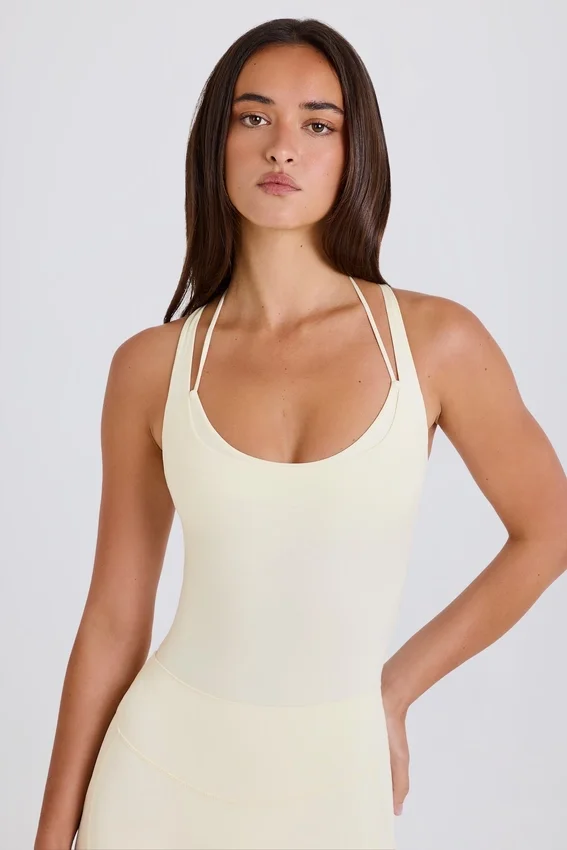 Stretchig bomullsjersey-bodys med korsrygg i krämfärg Stretchig bomullsjersey-bodys med korsrygg i krämfärg