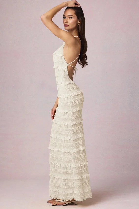 Tove maxiklänning med volanger, rygglös halterneck i ivory Tove maxiklänning med volanger, rygglös halterneck i ivory